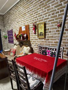 una sala da pranzo con un tavolo con una tovaglia rossa di Mekhtar famili 18th century old hause historical UNESCO HERITAGE List 1 minutes to Bukhara Old Town Square Est-Since 1826 for Walk in Guest PARKING, COZY ROOM, BEST LOCATION AND STRONG WIFI a Bukhara Altre 76 foto