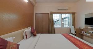a hotel room with a large bed and a window at Hotel Sumandeep 
