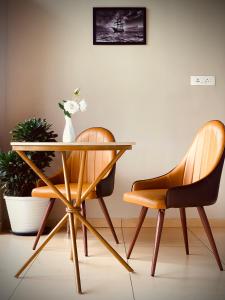 due sedie e un tavolo con un vaso sopra di Hayashi Resort a Meppādi