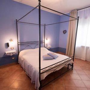sypialnia z łóżkiem z baldachimem w niebieskim pokoju w obiekcie Agriturismo w mieście Villafranca dʼAsti