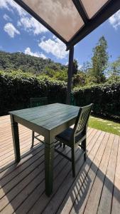 a picnic table and a chair on a deck at Cabana ECO - Teresópolis in Teresópolis +15 photos