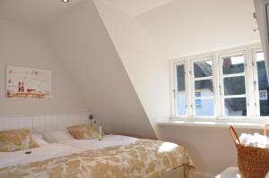 Una habitación blanca con una cama y una ventana en Rackmers Hof - Suiten Hotel garni mit Sauna, en Oevenum