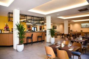 un ristorante con tavoli e sedie e un bar di LE CASTEL D'ALTI a Luchon