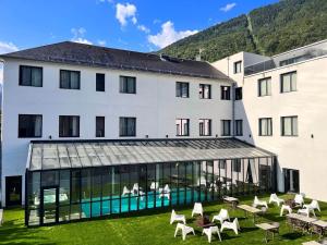 un grande edificio bianco con una piscina di fronte di LE CASTEL D'ALTI a Luchon