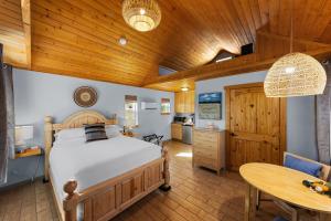 a bedroom with a bed and a wooden ceiling at Willow Street Cottages in Bluff