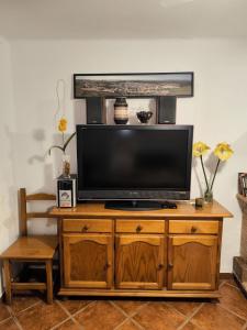 TV de pantalla plana en un centro de entretenimiento de madera en La Casita de Marisol, en El Real de la Jara