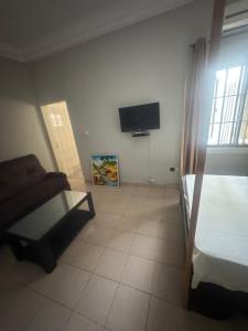 a room with a bed and a tv in it at Short and long stay in Agblangandan +9 photos