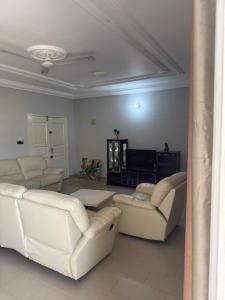 a living room with white couches and a tv at Short and long stay in Agblangandan