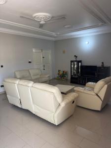 a living room with two white couches and a television at Short and long stay in Agblangandan