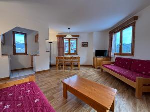 a living room with a red couch and a table at Résidence Saboia Clés Blanches in La Tania