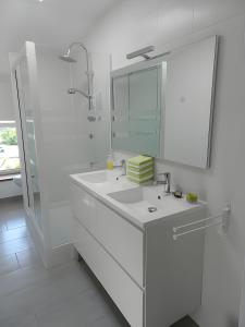 RiolsにあるLe Clos D'audioの洗面台と鏡のある白いバスルーム