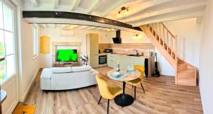 ein Wohnzimmer mit einer Couch und einem Tisch mit Stühlen in der Unterkunft Villa Margaux in Saint-Germain-sur-Vienne