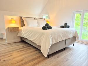 ein Schlafzimmer mit einem großen Bett mit zwei Teddybären darauf in der Unterkunft Villa Margaux in Saint-Germain-sur-Vienne + 24 Fotos
