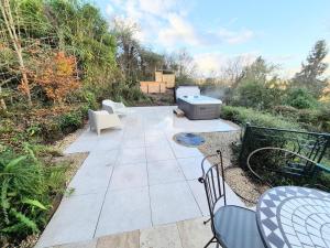 eine Terrasse mit Stühlen und einer Badewanne in der Unterkunft Villa Margaux in Saint-Germain-sur-Vienne
