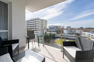 a balcony with chairs and a view of a city at ApartamentyPrzyMorzu Diva 553 in Kołobrzeg
