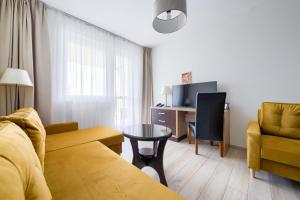 a living room with a couch and a table at ApartamentyPrzyMorzu Diva 553 in Kołobrzeg