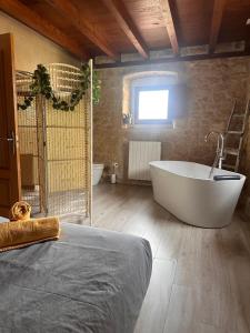 Un baño grande con bañera y ventana. en CASA RURAL PALACIO LOS LABREQUINES, en Villacomparada de Rueda