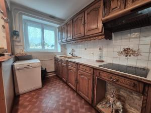 a kitchen with wooden cabinets and a white refrigerator at La maison d'à côté in Pluherlin