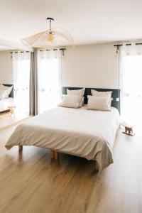 een groot wit bed in een kamer met ramen bij Villa Moka - private pool in Saumane-de-Vaucluse