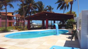 a swimming pool with a water slide in a resort at Pousada Red House in Flecheiras