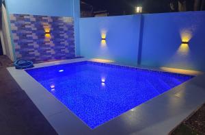 a swimming pool with blue lights in a room at Casanuestra Apartelle in Panglao