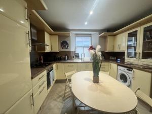 Una cocina con una mesa con un jarrón de flores encima. en The Quirky Townhouse, Hawick, en Hawick