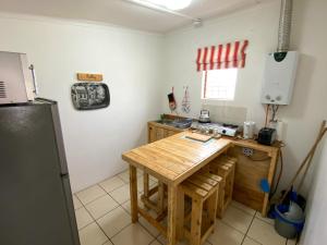 a kitchen with a wooden table in a room at Starboard Self Catering - St Helena Bay in Stompneusbaai
