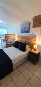 a bedroom with a large bed and a table at Starboard Self Catering - St Helena Bay in Stompneusbaai +1 photo