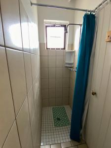 a shower with a blue shower curtain in a bathroom at Starboard Self Catering - St Helena Bay in Stompneusbaai