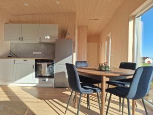 a kitchen with a wooden table and blue chairs at Oddnýjarhús in Höfn