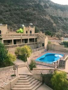 a large house with a swimming pool and stairs at Auberge jawahir aguerd 