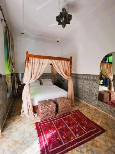 una camera con letto a baldacchino e tappeto di Riad Dar Al Fassia a Oujda
