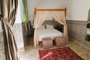 una camera da letto con un letto a baldacchino e due valigie di Riad Dar Al Fassia a Oujda