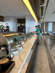 a man standing at a buffet line in a restaurant at Apec mandala Apartment - APEC Mandala Ocean View Mũi né-R0234 in Mui Ne