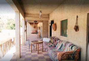 a living room with a couch and a table at Auberge jawahir aguerd paradise valley in Aguerd