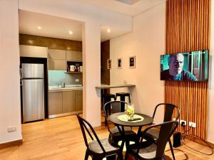 a living room with a table and chairs and a kitchen at La Rosa Apartment in Adrogué