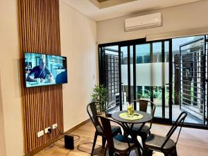 a living room with a table and a tv on a wall at La Rosa Apartment in Adrogué