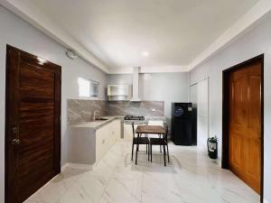 a kitchen with a table and a chair in it at Casanuestra Apartelle in Panglao