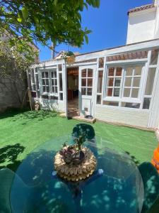 a glass table in front of a house at Casa acogedora puertas del Mar in La Serena