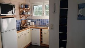 eine Küche mit einem weißen Kühlschrank und einer Spüle in der Unterkunft Cocon sur mer in Varengeville-sur-Mer + 16 Fotos