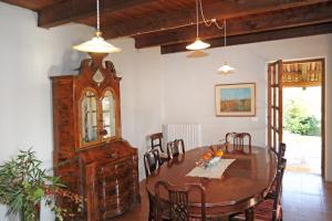 a dining room with a table and a wooden cabinet at Il portico sulla valle, Bioglio in Valle San Nicolao +28 photos