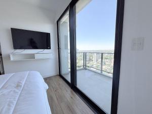a bedroom with a bed and a large glass window at Dpto con piscina a pasos del Shopping del Sol in Asuncion +43 photos