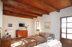 a living room with a couch and a tv at Il portico sulla valle, Bioglio in Valle San Nicolao