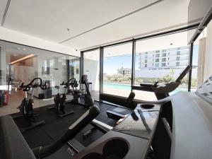 a gym with treadmills and ellipticals in a building at Dpto con piscina a pasos del Shopping del Sol in Asuncion