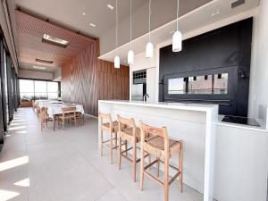 a kitchen with a bar with chairs and a table at Dpto con piscina a pasos del Shopping del Sol in Asuncion