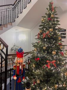a christmas tree with a nutcracker next to a staircase at AR Apartamenty in Poznań