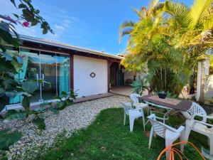 eine Terrasse mit Tisch und Stühlen vor einem Haus in der Unterkunft Casa Praia Alegre in Penha