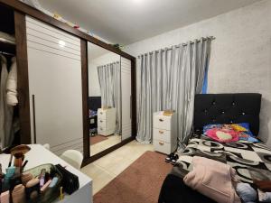 ein Schlafzimmer mit einem Bett und einem großen Spiegel in der Unterkunft Casa Praia Alegre in Penha