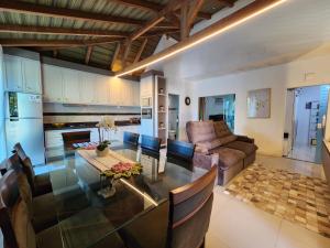 eine Küche und ein Wohnzimmer mit einem Tisch und einer Couch in der Unterkunft Casa Praia Alegre in Penha + 4 Fotos