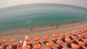 un gruppo di sedie e ombrelloni in spiaggia di Grand Hotel President a Siderno Marina